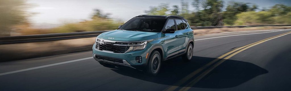 Kia Seltos driving on a sunlit highway with trees and motion blur in the background