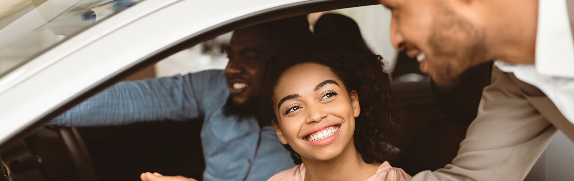 Happy couple sitting inside a car.